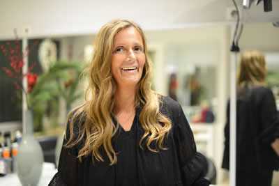 Lächelnde Mitarbeiterin mit langen blonden Haaren